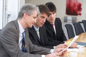 three businessmen are discussing something on a meeting